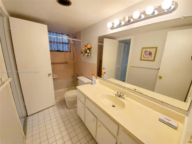 a spacious bathroom with a granite countertop sink toilet and shower