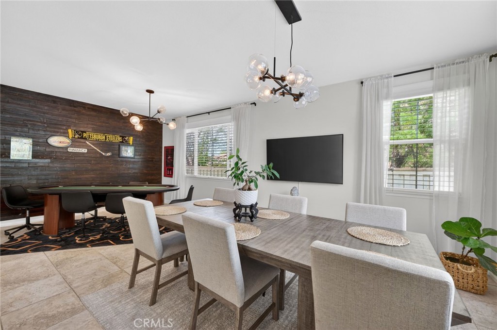 45136 Willowick Street Temecula, CA 92592 - Photo 13 of 75 a dining room with furniture a flat screen tv and a chandelier