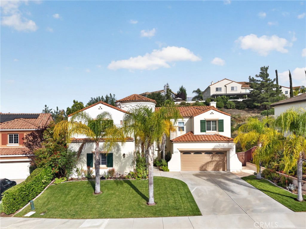 45136 Willowick Street Temecula, CA 92592 - Photo 59 of 75 a view of a white house with a yard and table and chairs under an umbrella