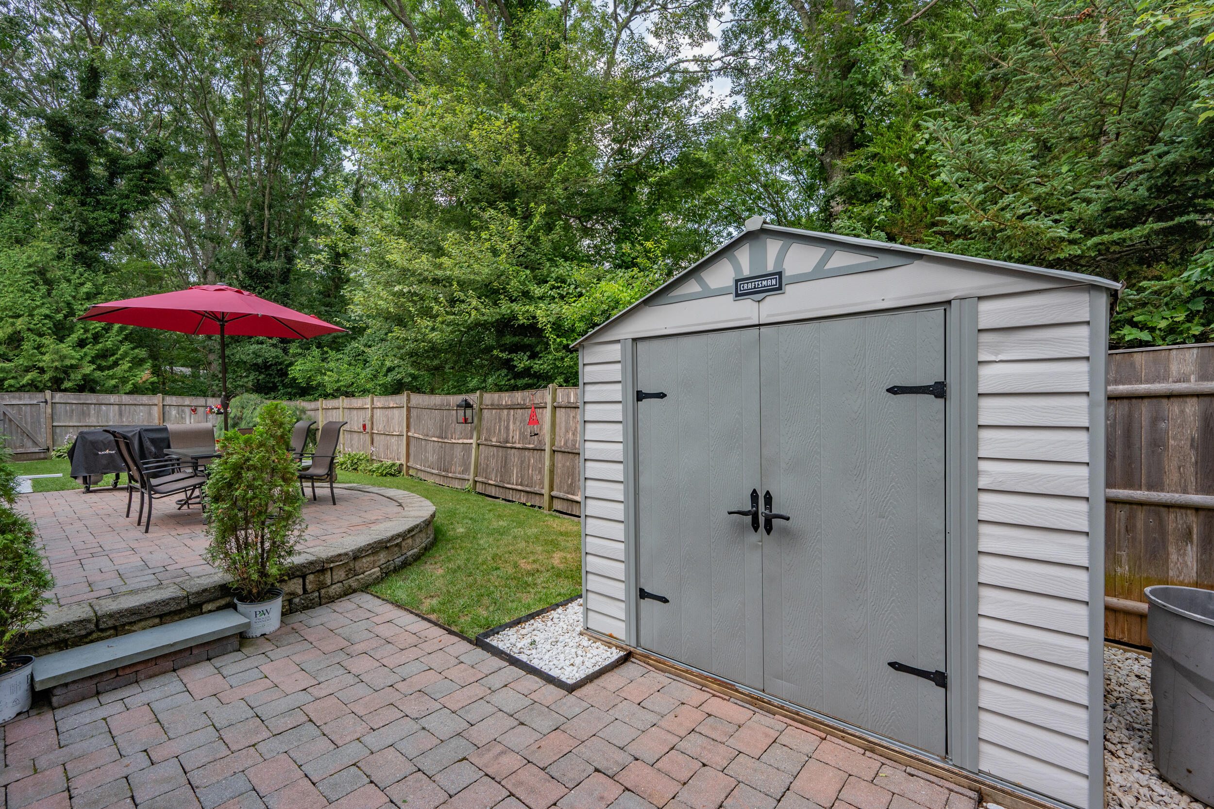 19 Shagbark Road Forestdale, MA 02644 - Photo 36 of 44 a backyard of a house with table and chairs under an umbrella
