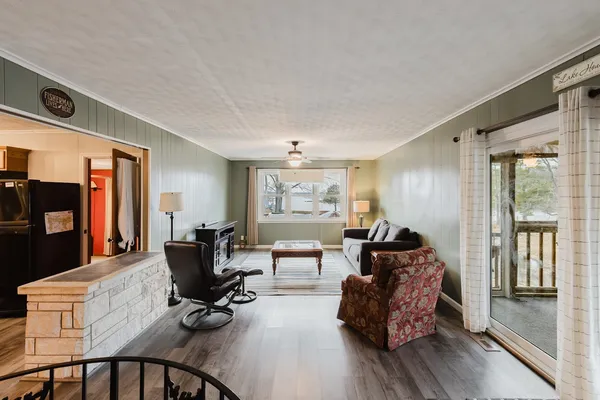 a living room with furniture a flat screen tv and a floor to ceiling window