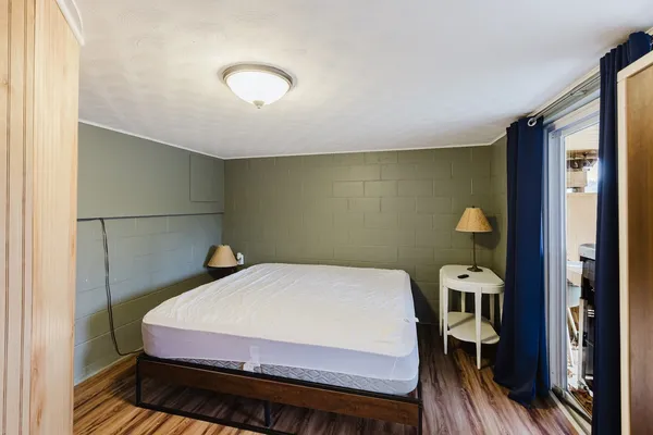 a bedroom with a bed and a flat tv screen on the wall