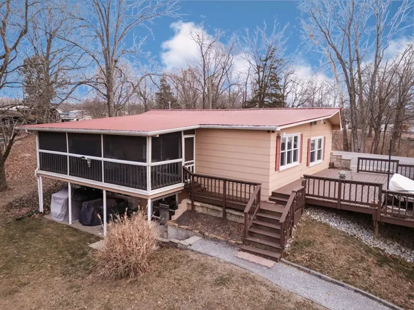 a view of a house with backyard and trees