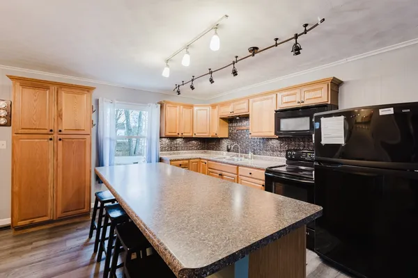 a kitchen with stainless steel appliances granite countertop a sink stove and cabinets