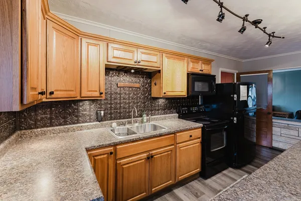 a kitchen with granite countertop a table chairs stove a sink dishwasher and cabinets