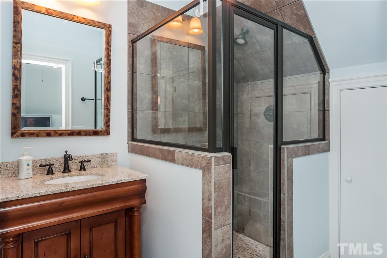 3105 Raymond Street Raleigh, NC 27607 - Photo 21 of 22 a bathroom with a sink a mirror a vanity and shower