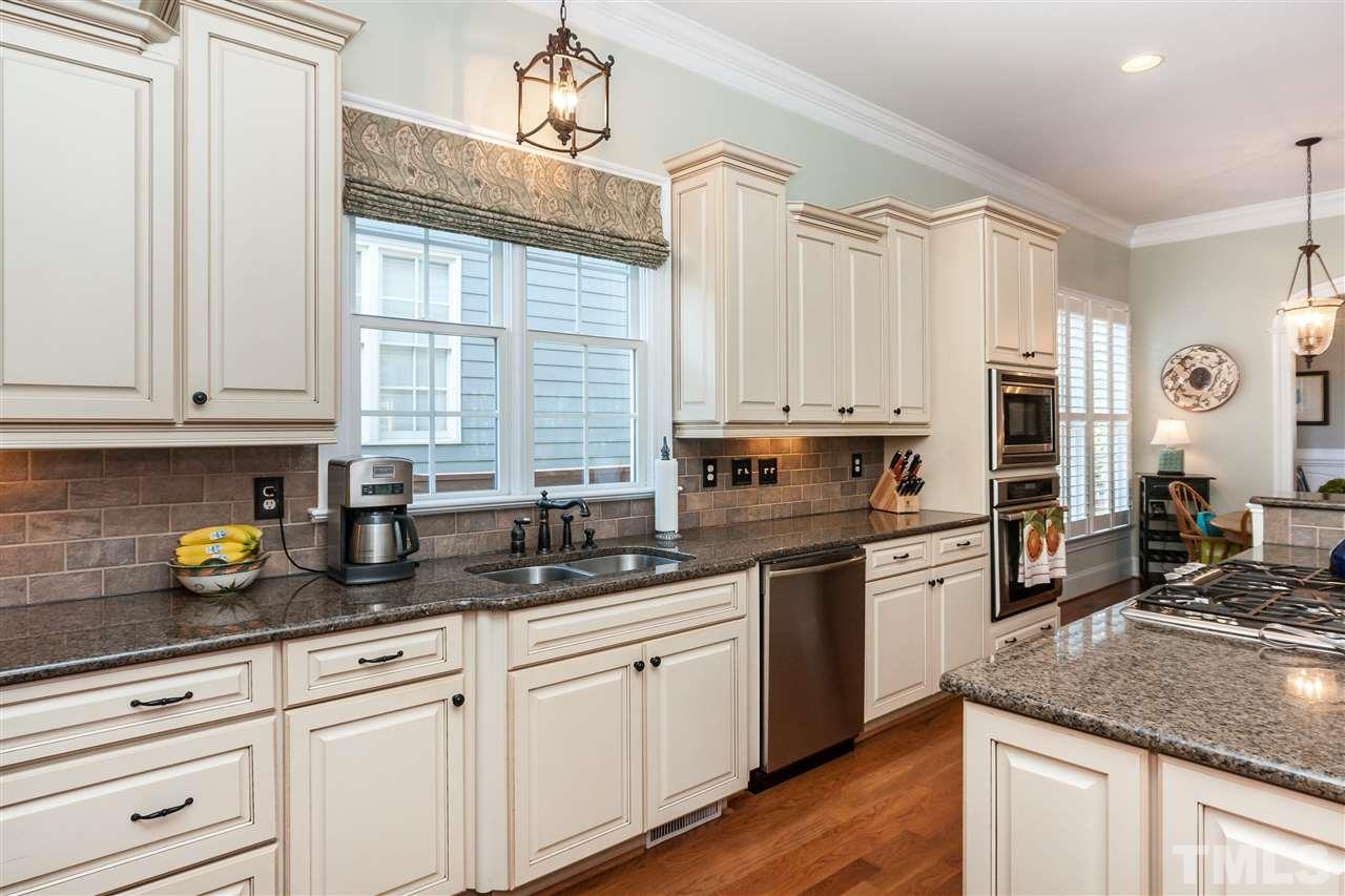 3105 Raymond Street Raleigh, NC 27607 - Photo 9 of 22 a kitchen with granite countertop a sink stainless steel appliances and cabinets