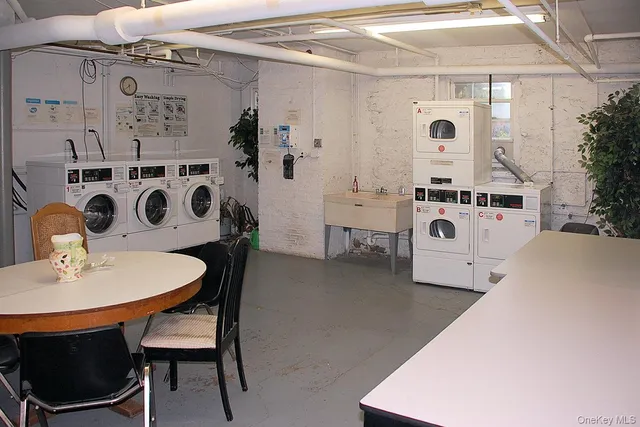 a kitchen with stainless steel appliances a white table and chairs
