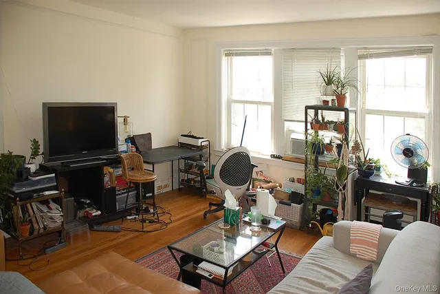 a living room with furniture a flat screen tv and a window