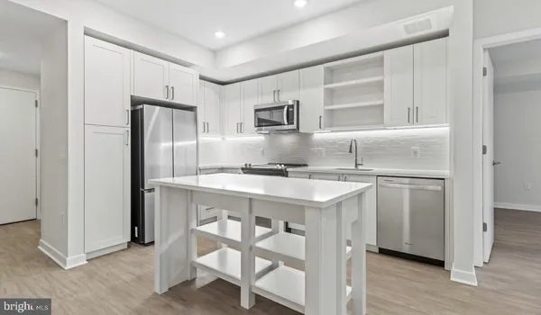 a kitchen with stainless steel appliances granite countertop a sink and a microwave