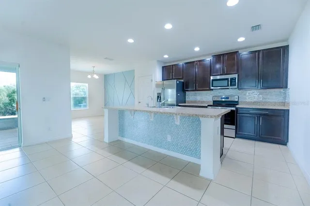 a kitchen with stainless steel appliances granite countertop a sink and a stove