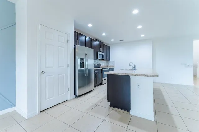 a kitchen with stainless steel appliances granite countertop a refrigerator and a sink