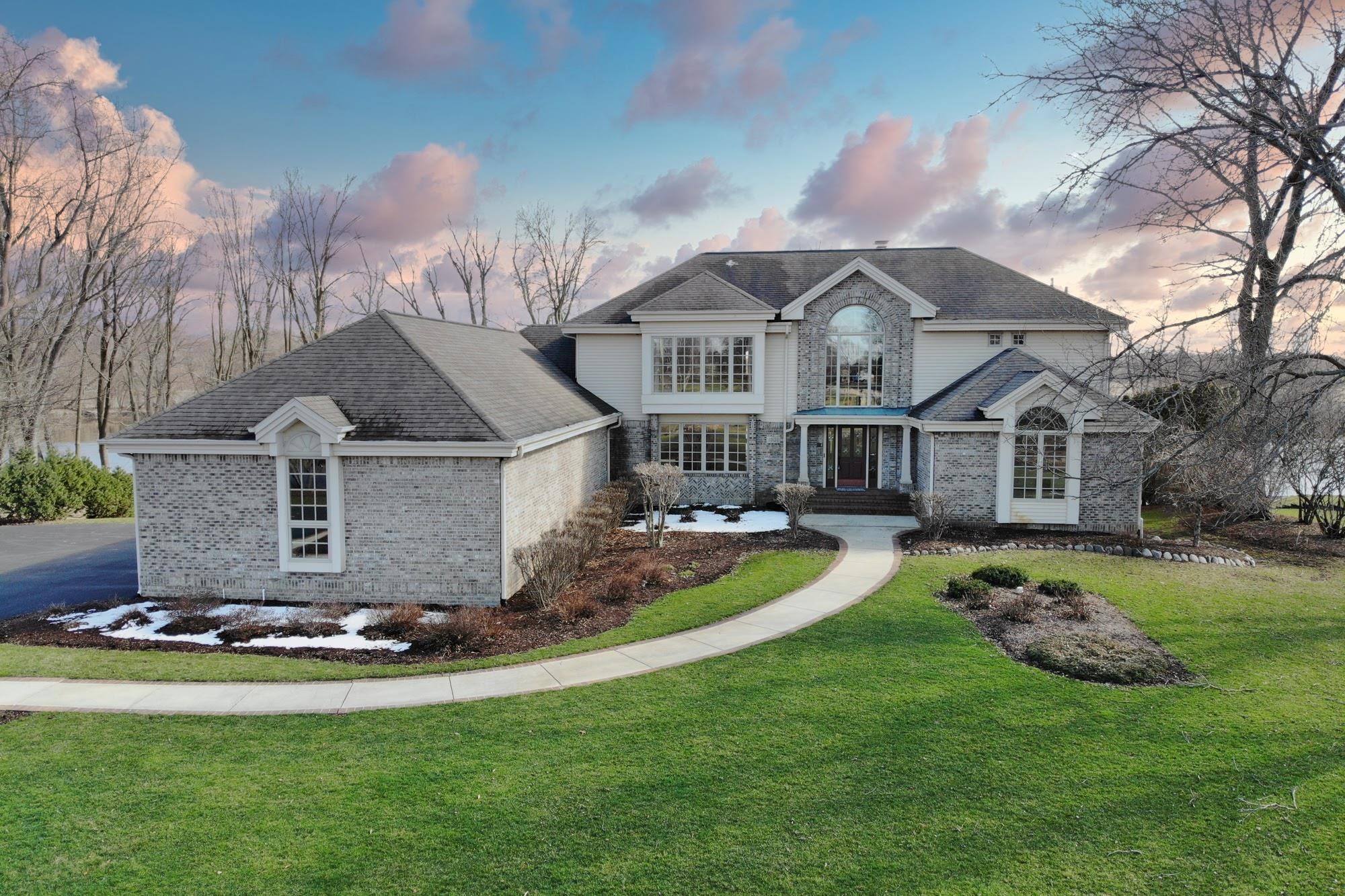 9805 Rivers Bend Drive Roscoe, IL 61073 - Photo 1 of 49 a front view of a house with a garden and trees