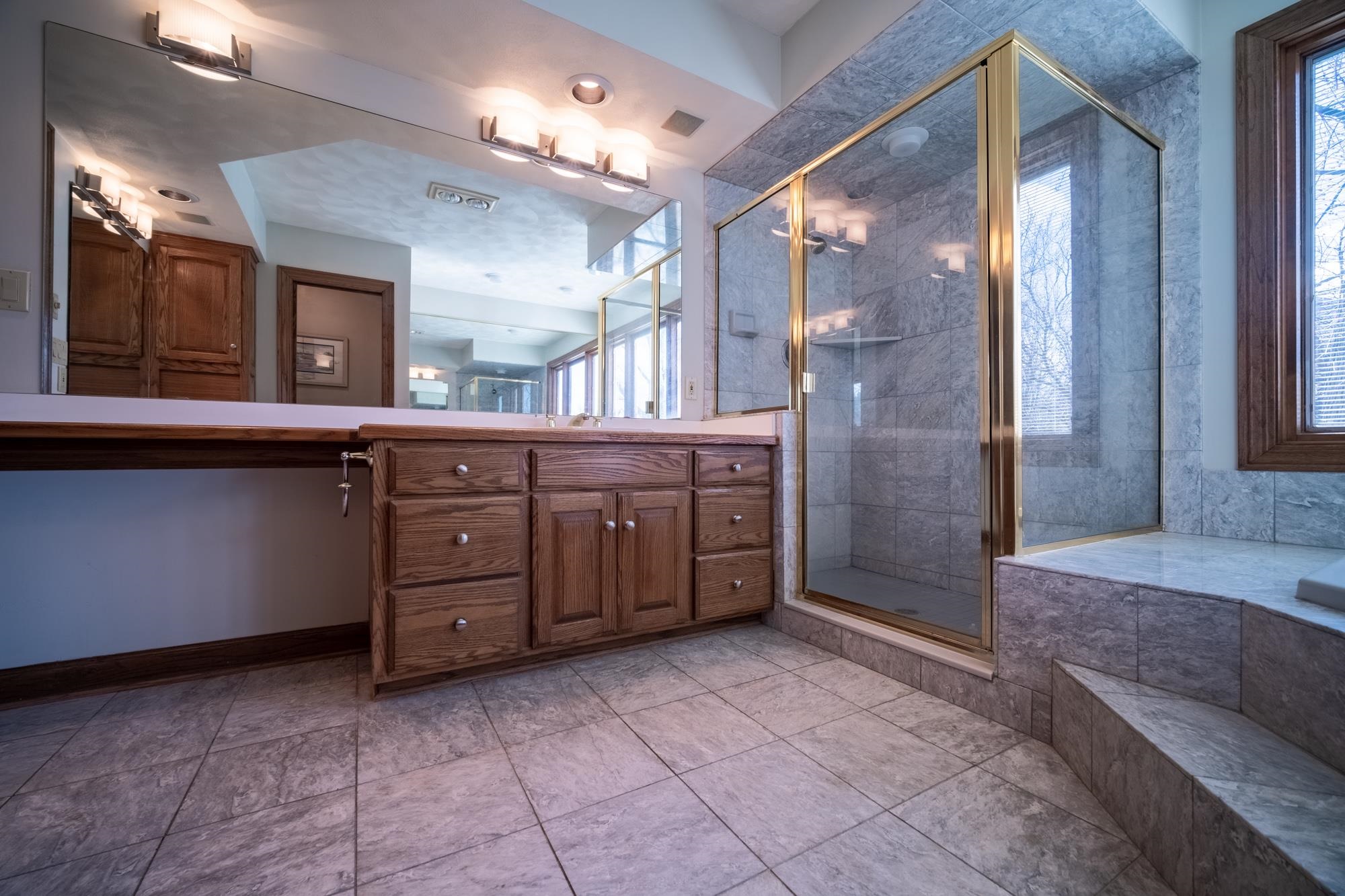 9805 Rivers Bend Drive Roscoe, IL 61073 - Photo 21 of 49 a bathroom with a granite countertop sink a mirror and a shower
