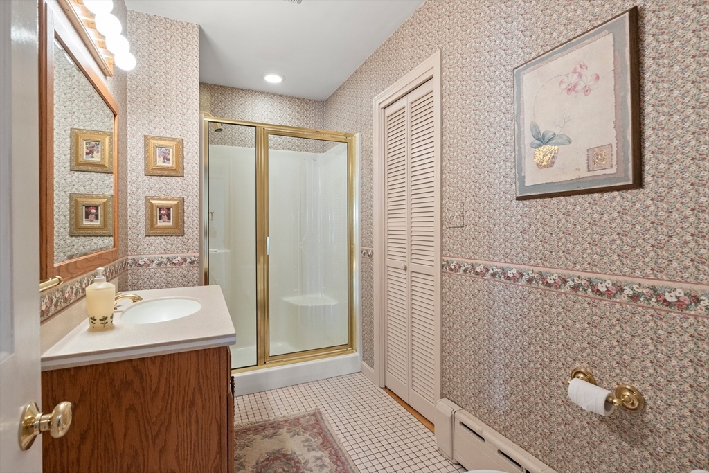 25 High Street Beverly, MA 01915 - Photo 14 of 42 a bathroom with a sink a mirror and a shower