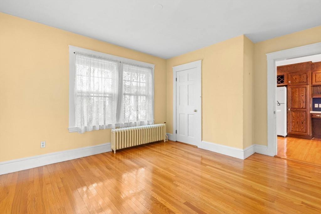 25 High Street Beverly, MA 01915 - Photo 16 of 42 a view of an empty room with wooden floor and a window
