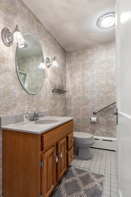 25 High Street Beverly, MA 01915 - Photo 27 of 42 a bathroom with a sink a toilet and a mirror