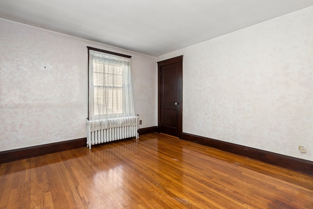 25 High Street Beverly, MA 01915 - Photo 29 of 42 an empty room with wooden floor and windows