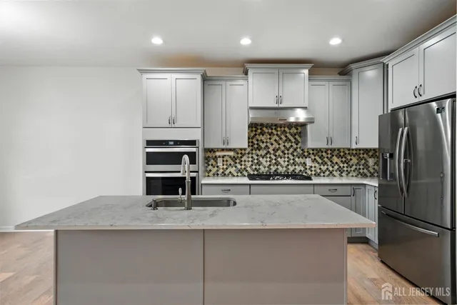 a view of kitchen with sink and refrigerator