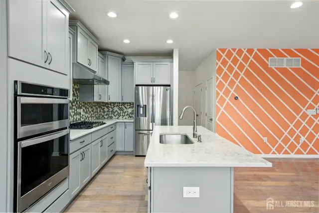 a kitchen with stainless steel appliances granite countertop a sink stove and refrigerator