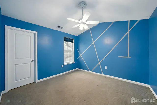 an empty room with windows and ceiling fan