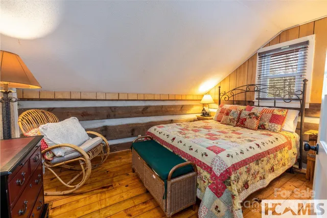 a bedroom with a bed and a lamp on dresser