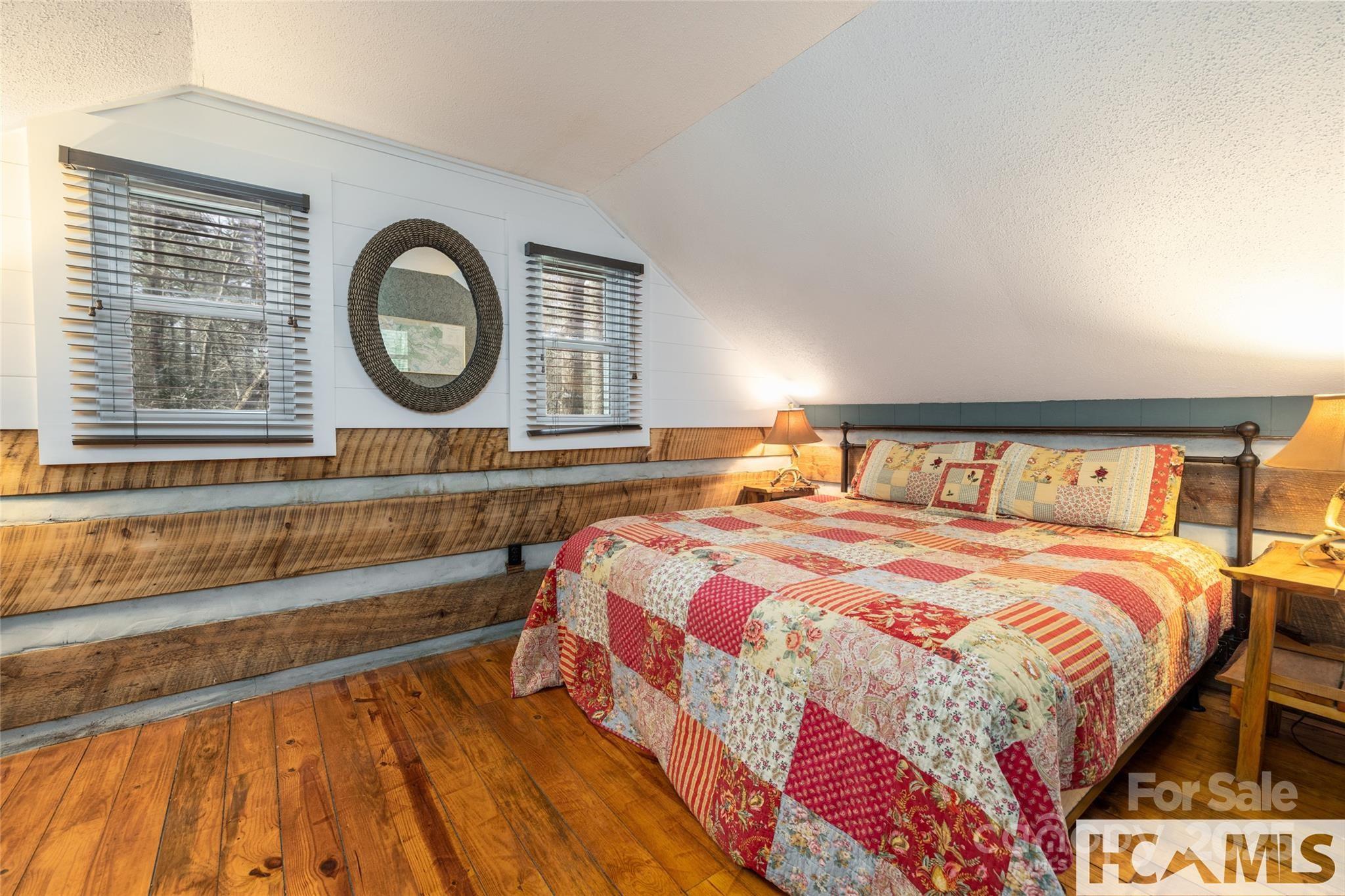 1524 McCall Road Cashiers, NC 28717 - Photo 18 of 35 a bedroom with a bed and a lamp on dresser