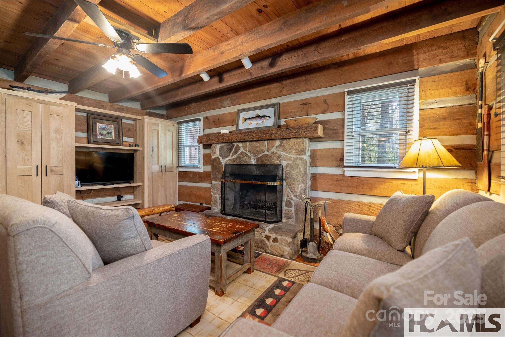 1524 McCall Road Cashiers, NC 28717 - Photo 6 of 35 a living room with furniture a flat screen tv and a fireplace