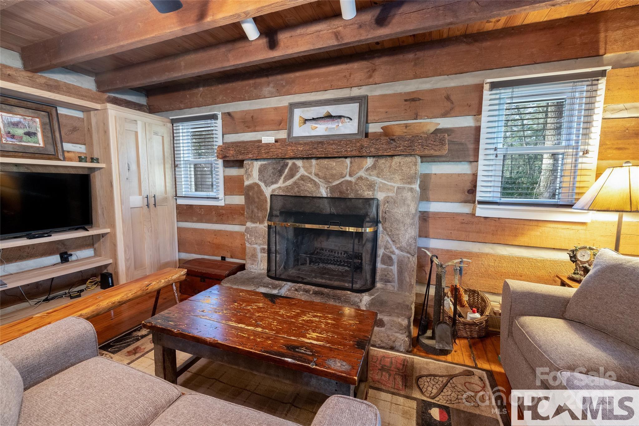 1524 McCall Road Cashiers, NC 28717 - Photo 7 of 35 a living room with furniture a flat screen tv and a fireplace