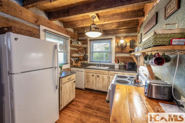 a kitchen with stainless steel appliances granite countertop a refrigerator a stove and a sink with wooden floor