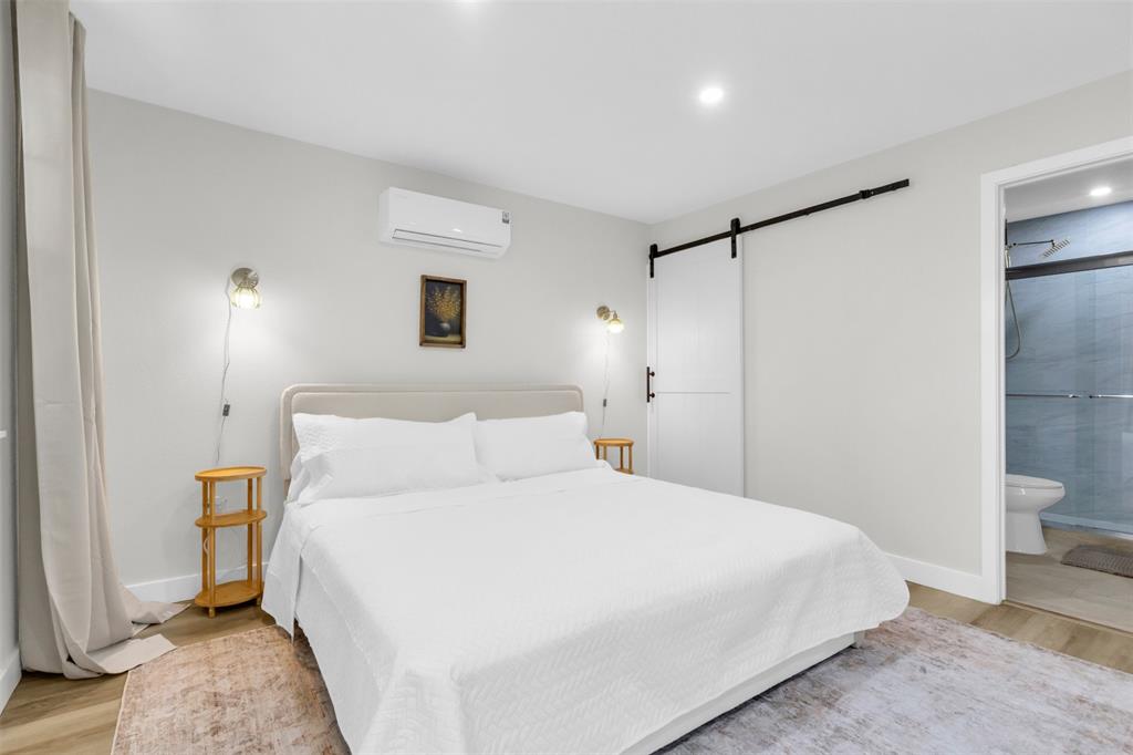 4121 Junius Street, Unit B Dallas, TX 75246 - Photo 14 of 32 Bedroom featuring light-toned walls and wood-finish flooring