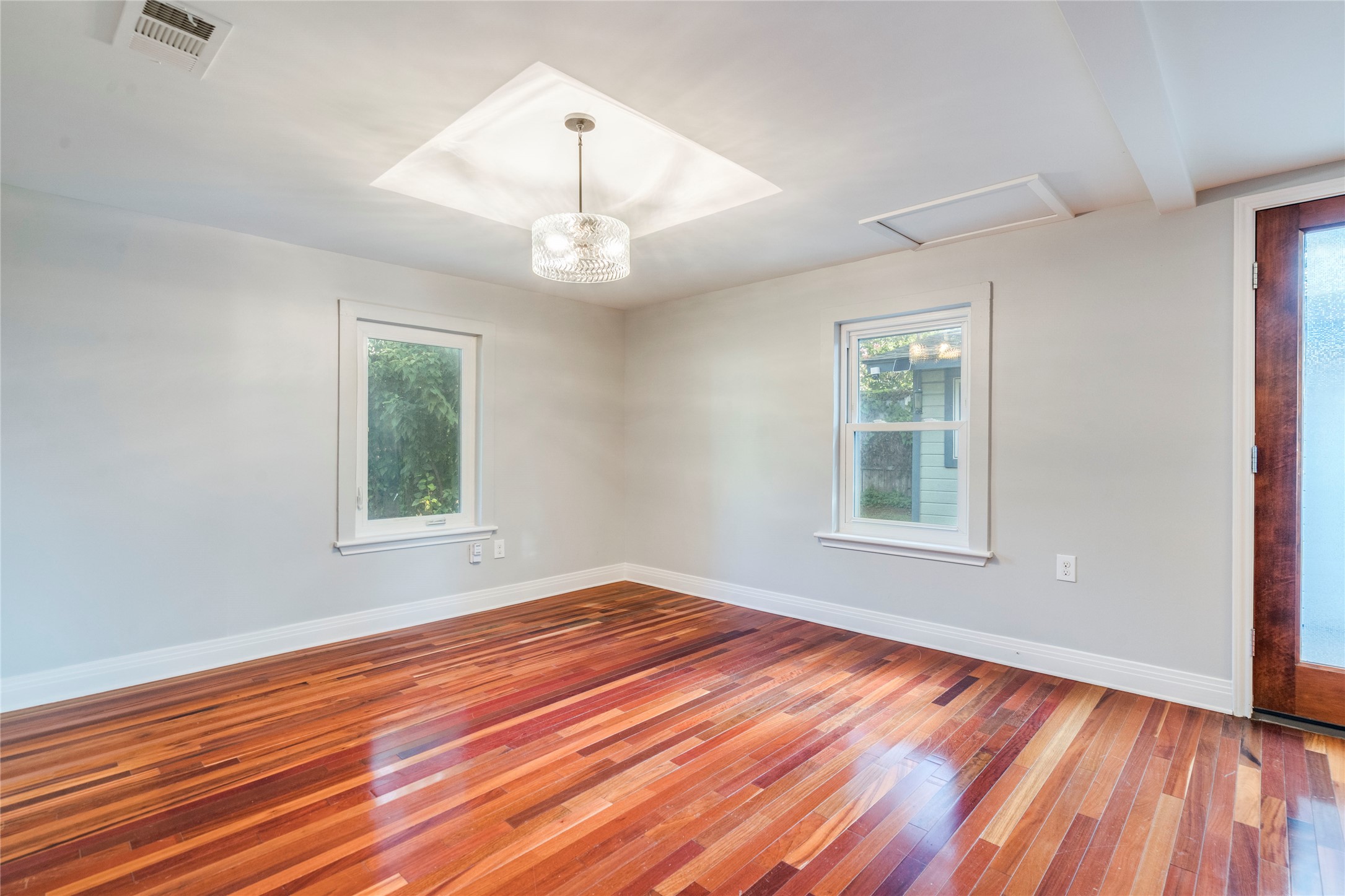 2314 Santa Rosa Street Austin, TX 78702 - Photo 9 of 29 Rich hardwood flooring complements a striking chandelier in this naturally illuminated room.
