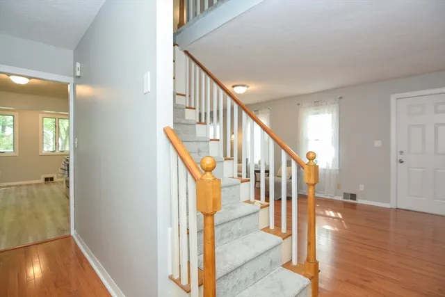 a view of a hallway with wooden floor and staircase