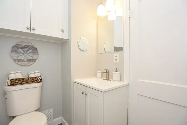 a bathroom with a toilet a sink and a mirror