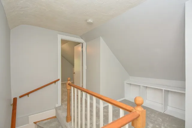 a view of staircase with railing and white walls