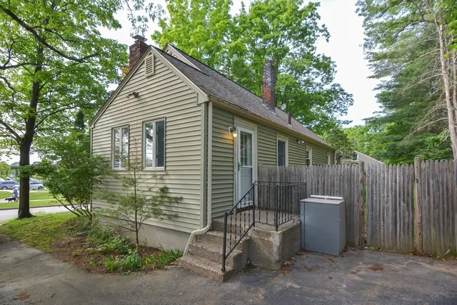 a view of a backyard with large trees and wooden fence