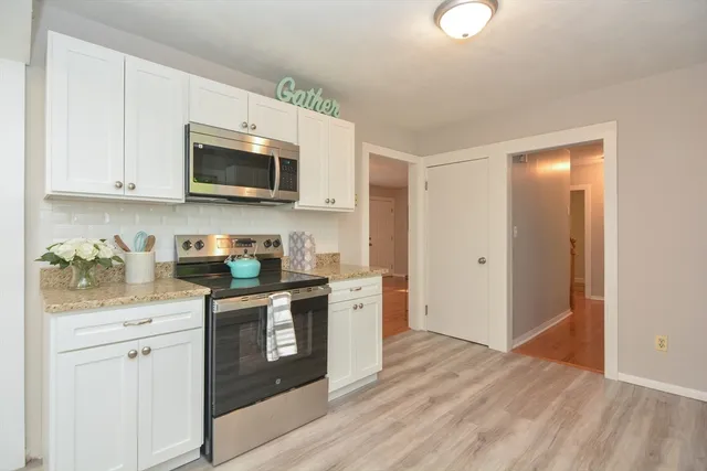 a kitchen with stainless steel appliances granite countertop a stove a sink and a microwave