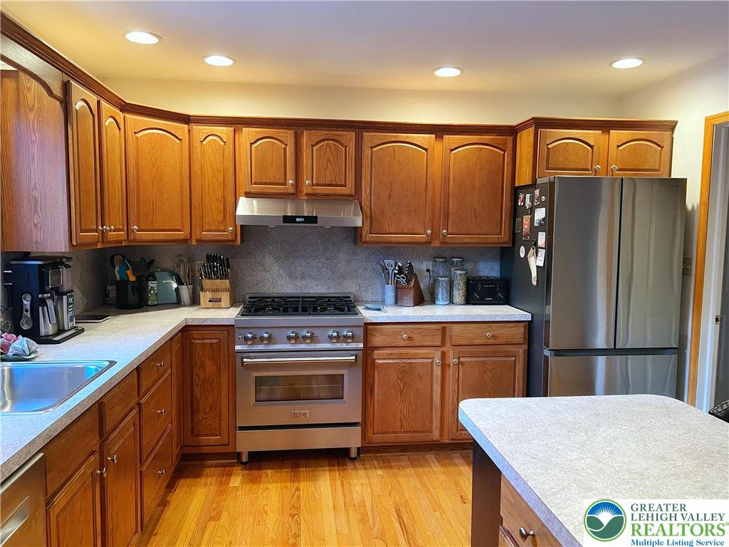 90 Halina Way Kunkletown, PA 18058 - Photo 13 of 32 a kitchen with stainless steel appliances granite countertop a refrigerator a stove and a sink with wooden cabinets