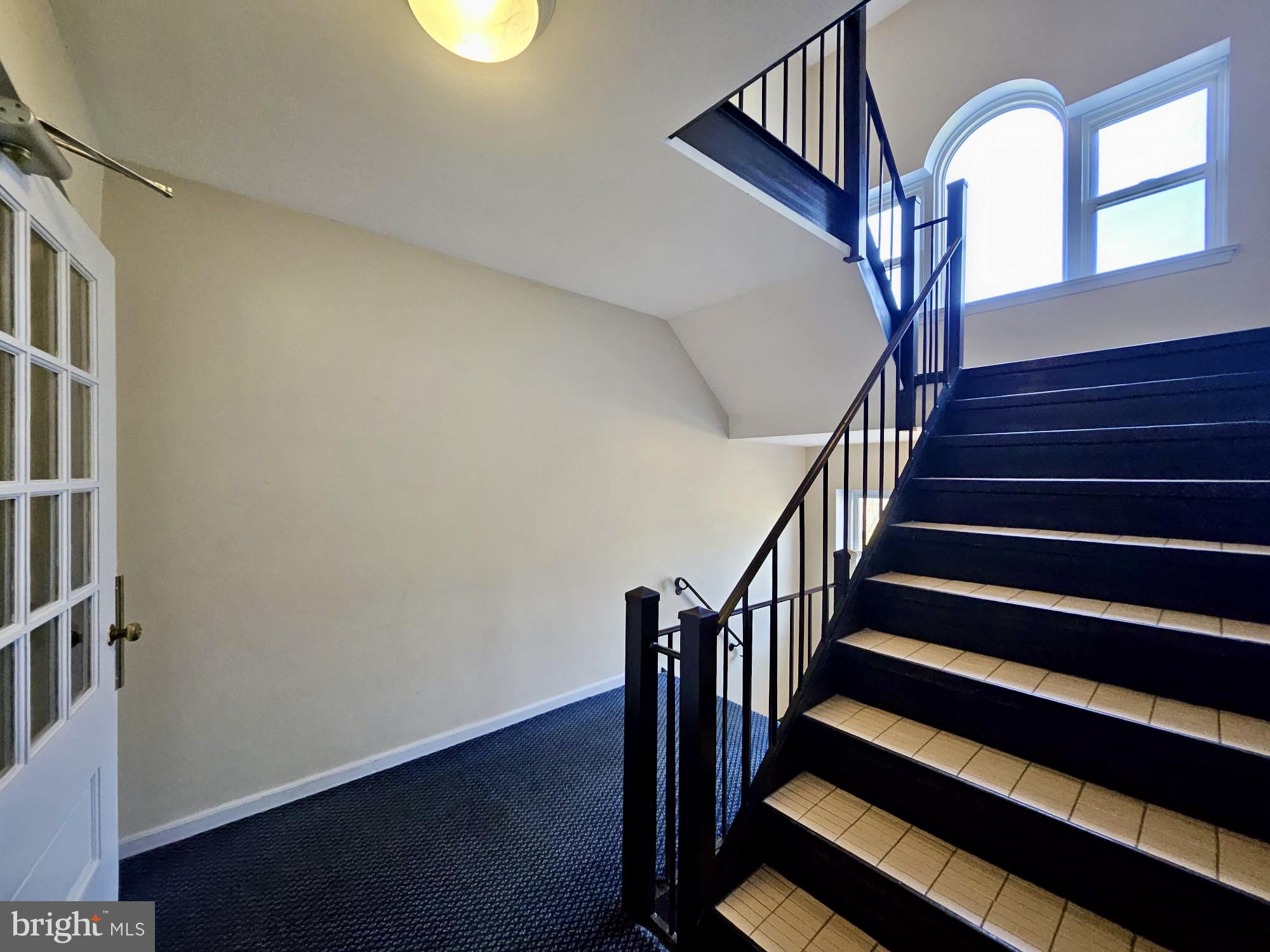 412 North Wayne Avenue, Unit 203 Wayne, PA 19087 - Photo 4 of 21 a view of staircase with lots of frames on wall and wooden floor