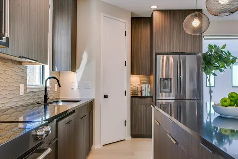a kitchen with stainless steel appliances granite countertop a refrigerator and a sink