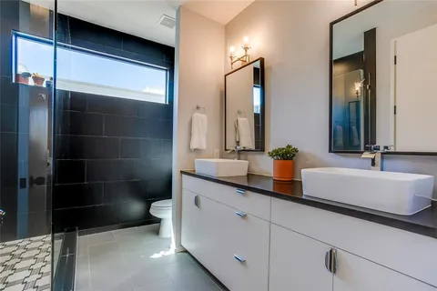 a bathroom with a sink a toilet and shower