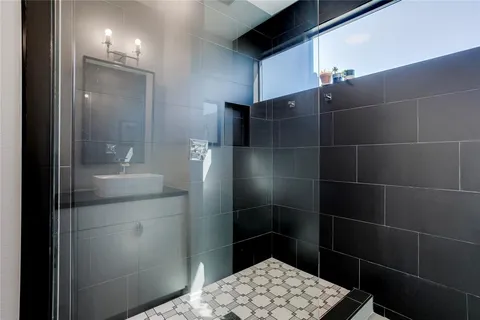 a bathroom with a glass shower door and a sink