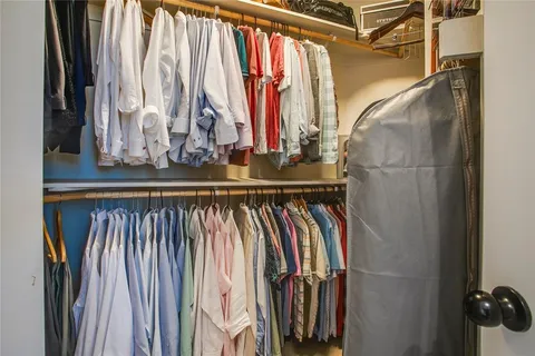 a view of walk in closet with clothes and shoes