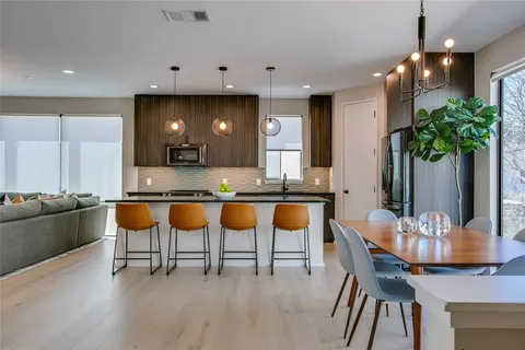 a kitchen with stainless steel appliances kitchen island granite countertop a table and chairs in it