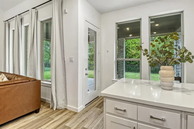 a kitchen with white cabinets and a window