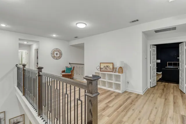 a view of a bedroom with wooden floor and windows