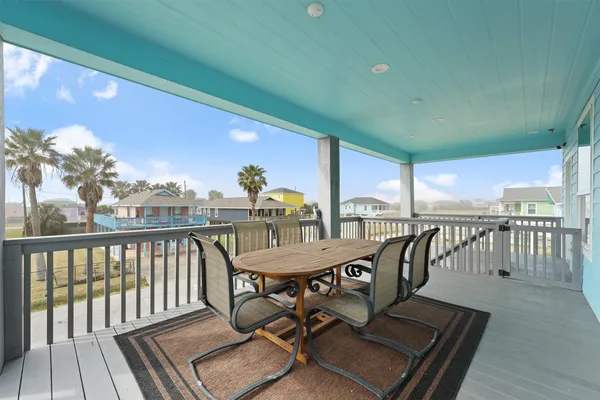 a view of a balcony with chairs and wooden floor