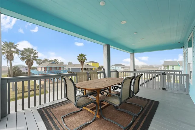 a view of a balcony with chairs and wooden floor