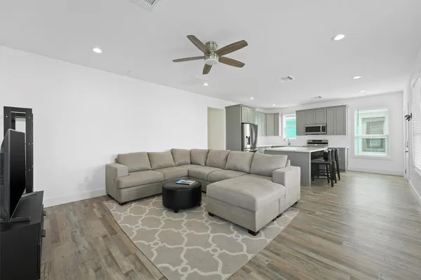 a living room with furniture and kitchen view
