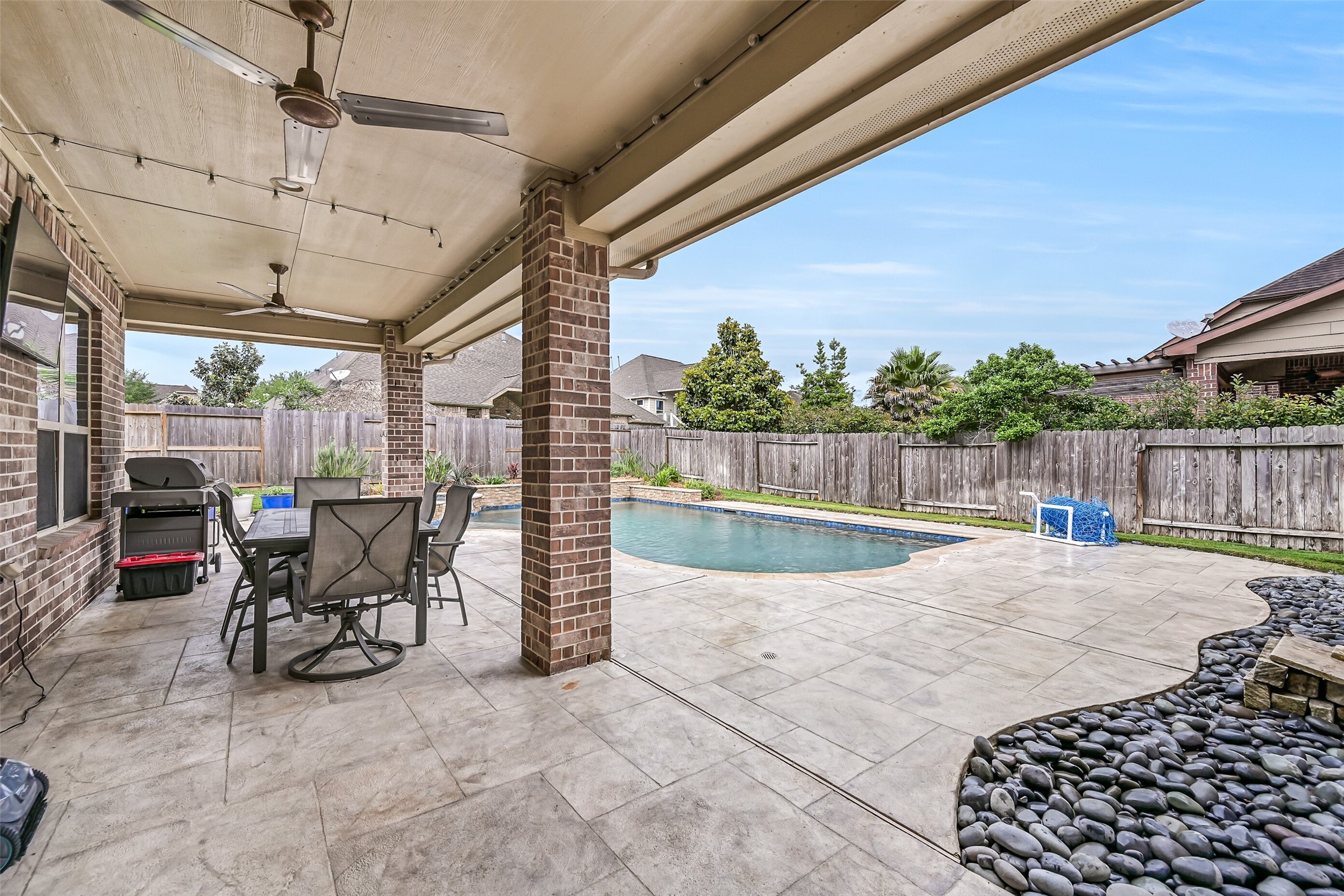 1008 Point Isabel Lane Friendswood, TX 77546 - Photo 45 of 50 A spacious covered patio with dual ceiling fans provides a comfortable outdoor living area with room for dining and seating. The space overlooks the heated pool and spa and offers shade for year round use.